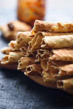 Gofret, lezzetli ve güzel kokulu haşlanmış yoğunlaştırılmış süt siyah bir tablo ile rulo