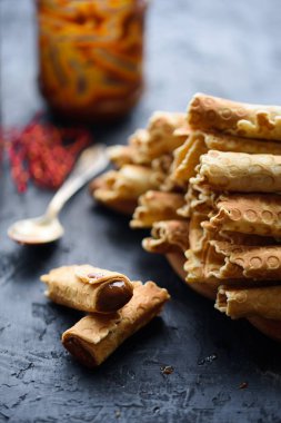 Gofret, lezzetli ve güzel kokulu haşlanmış yoğunlaştırılmış süt siyah bir tablo ile rulo