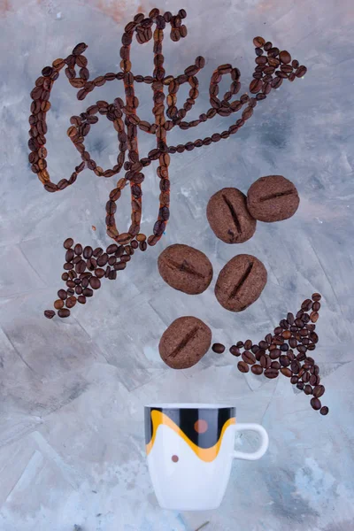 Delicious and fragrant coffee in the form of coffee, with grains of coffee, and the inscription on a light background.