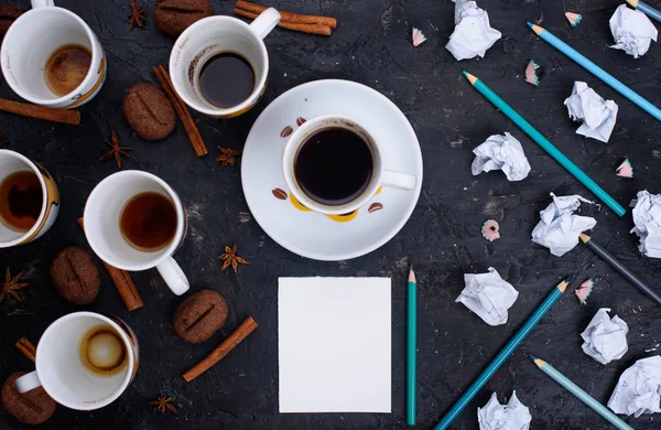 Delicious and fragrant coffee in the form of coffee, with grains of coffee. Cups of coffee in beautiful cups. Cinnamon sticks on a black background