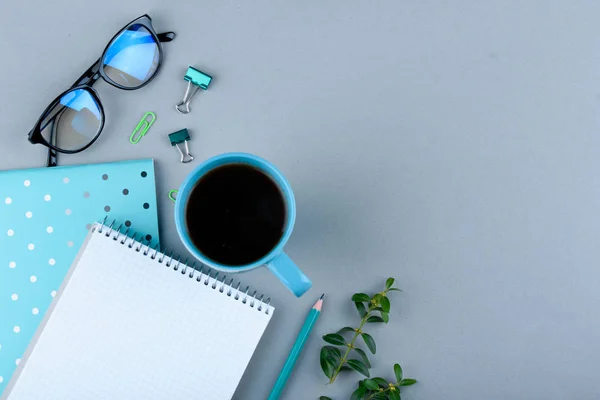 Синяя тетрадь с голубым карандашом на сером фоне. Телефон, стаканы и чашка кофе . — стоковое фото