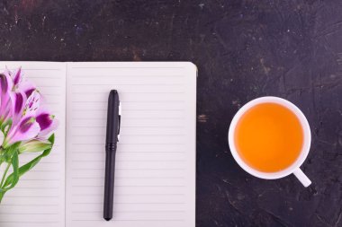 Beyaz bir fincan kokulu çay, güzel çiçekler, siyah bir backgrou