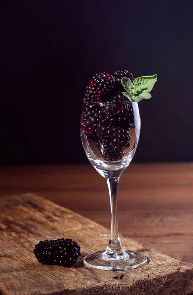 Reife und schmackhafte Brombeeren im Glaskelch mit Minzblatt — Stockfoto