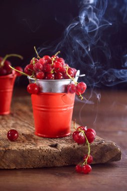 Ahşap arka planda soğutulmuş kırmızı kuş üzümü