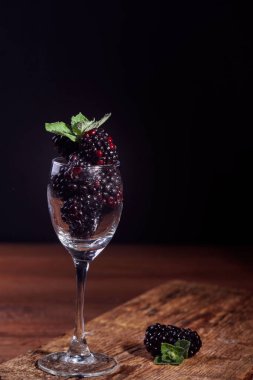 Nane yaprağı ile bir cam kadeh olgun ve lezzetli böğürtlen