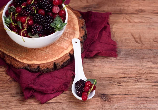 Reife und schmackhafte Beeren in weißer Schüssel auf dem Tisch — Stockfoto