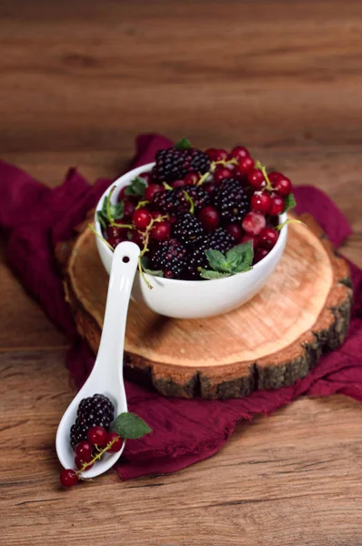 Reife und schmackhafte Beeren in weißer Schüssel auf dem Tisch — Stockfoto