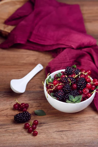 Reife und schmackhafte Beeren in weißer Schüssel auf dem Tisch — Stockfoto