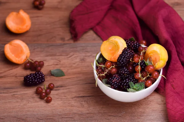 Reife und schmackhafte Beeren in weißer Schüssel auf dem Tisch — Stockfoto