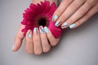 Pastel arka planda, kadın ellerde güzel narin manikür.