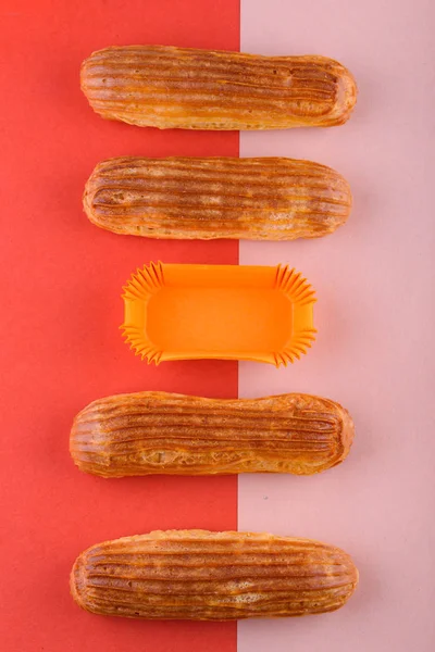 Sabrosas y hermosas eclairs sobre un fondo de color. Delicioso postre — Foto de Stock