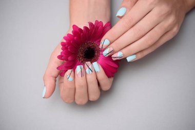 Pastel arka planda, kadın ellerde güzel narin manikür.