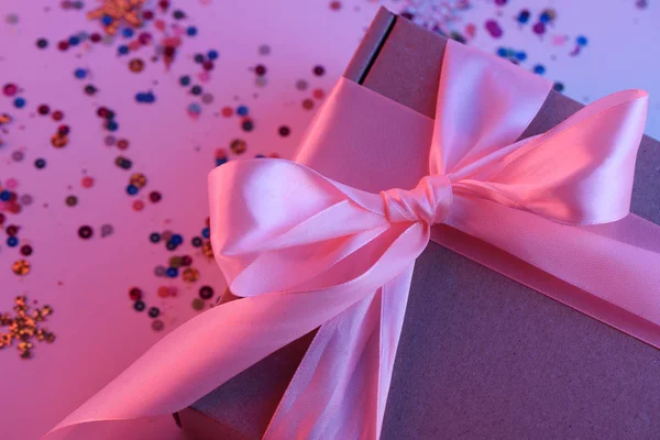 霓虹灯下带粉红色丝带的礼品盒 — 图库照片
