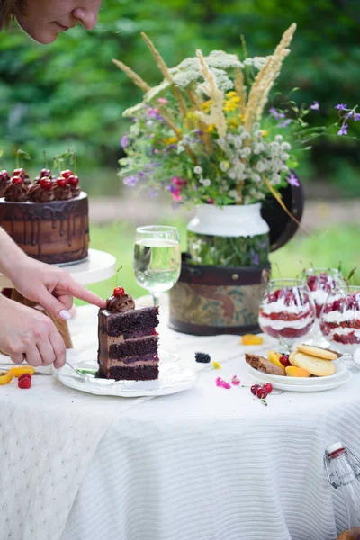 Delicioso pastel de chocolate, terciopelo rojo en un vaso, flores silvestres, bayas . — Foto de Stock