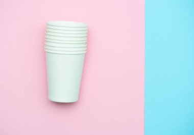 İçecekler ve kahve için kağıt beyaz bardaklar. Gözlük renkli arka plan