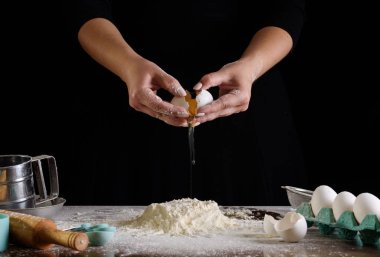 Şefin el çırpışı ve siyah arka planda beyaz un.