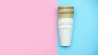 İçecekler ve kahve için kağıt beyaz bardaklar. Gözlük renkli arka plan