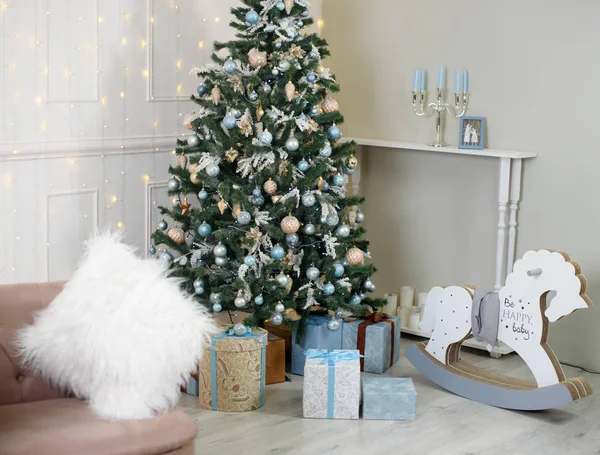 Hermoso árbol de Navidad, luces, bokeh, sofá beige. Años nuevos, regalos . — Foto de Stock