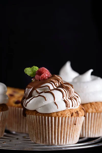 Delizioso cupcake aromatizzato con lamponi, panna bianca e glassa al cioccolato . — Foto Stock