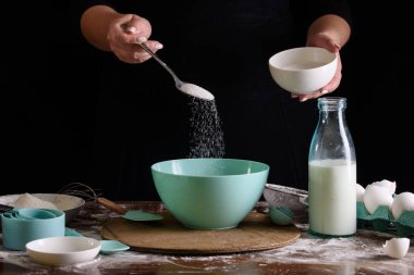 Şefin el çırpışı ve siyah arka planda beyaz un.