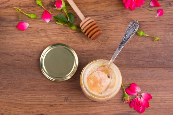 Honingraat met houten Dipper en verse bloesem, pot met honing en plaat met vintage lepels op donkere rustieke achtergrond. — Stockfoto