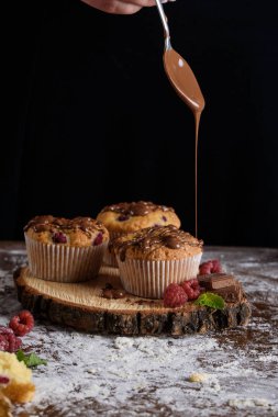 Ahududu, beyaz krema ve çikolata krema ile lezzetli aromalı cupcake.