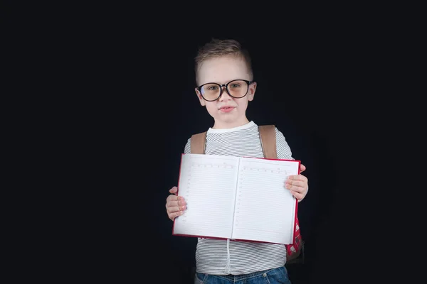 Joyeux petit garçon souriant sur fond noir. Je regarde la caméra. Concept scolaire — Photo