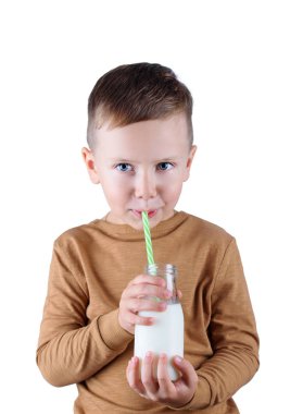 Çocuk elinde bir bardak süt ve ev yapımı kurabiye tutuyor..