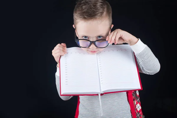 Cheerful smiling little boy on a black background. Looking at camera. School concept — Stock Photo, Image