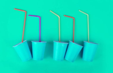 Eko tema. Parlak bir arka plan üzerinde plastik bardak ve pipetler.