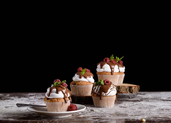 The process of making cupcakes, coating a cream from a pastry bag in the hands of a pastry chef.