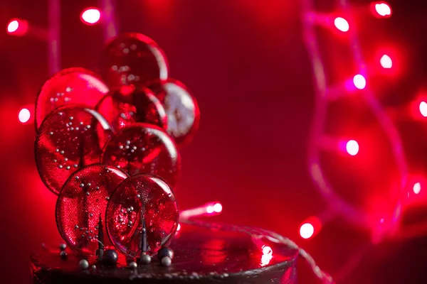 Lollipops lindos e brilhantes com um tom vermelho e luzes — Fotografia de Stock
