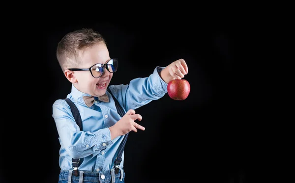 Fröhlich lächelnder kleiner Junge auf schwarzem Hintergrund. Blick in die Kamera. Schulkonzept — Stockfoto