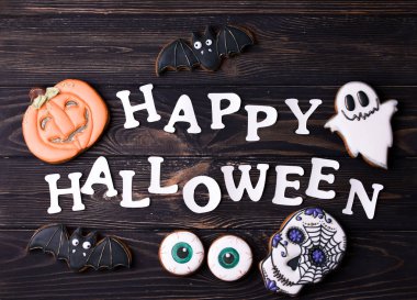 Cadılar Bayramı parti içeriği. Küçük renkli tatlılar ile beyaz halloween yazıt.