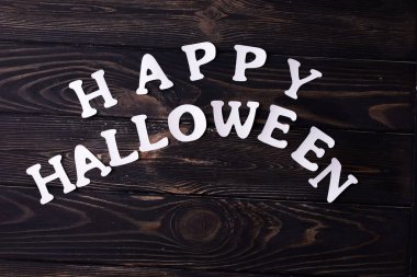 Cadılar Bayramı parti içeriği. Küçük renkli tatlılar ile beyaz halloween yazıt.