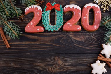 2020 numaralı Noel kurabiyesi ahşap zemin üzerinde aromatik tarçın çubuklarıyla
