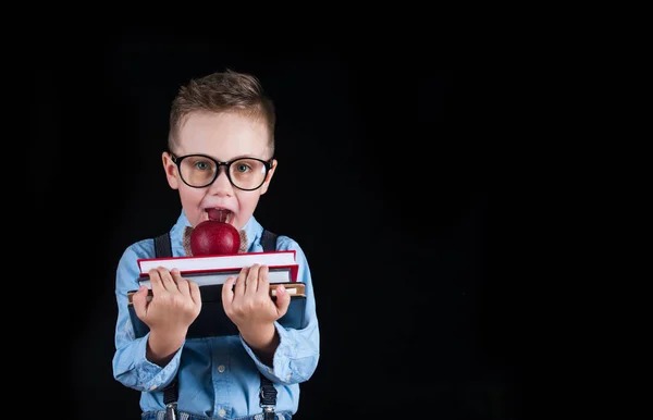 Fröhlich lächelnder kleiner Junge auf schwarzem Hintergrund. Blick in die Kamera. Schulkonzept — Stockfoto