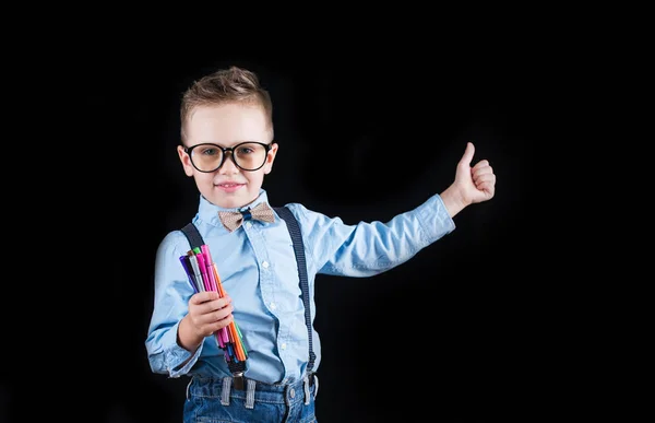 Fröhlich lächelnder kleiner Junge auf schwarzem Hintergrund. Blick in die Kamera. Schulkonzept — Stockfoto