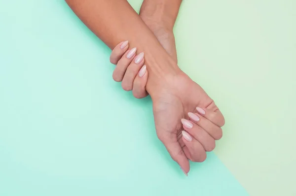 Elegante manicure feminina na moda. As mãos da mulher bonita no fundo macio . — Fotografia de Stock