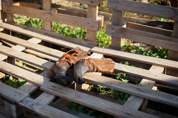 Cowboy boots on a ranch. Wood pallets. Farm — Stock Photo, Image