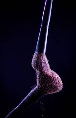 Siyah arkaplanda pembe makyaj fırçası