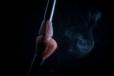 Siyah arkaplanda pembe makyaj fırçası