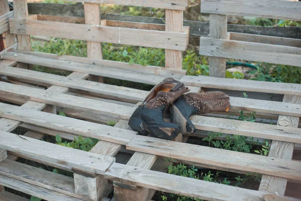 Cowboy boots on a ranch. Wood pallets. Farm — Stock Photo, Image