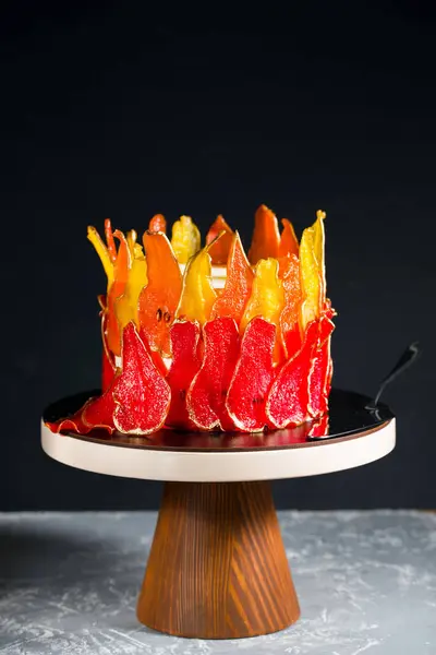 Прекрасный и вкусный десерт. Торт на подставке украшен красными и желтыми грушами . — стоковое фото