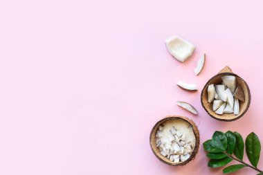 Parça parça hindistan cevizi, pembe arka planda hindistan cevizi talaşı. Yukarıdan bak. Mesaj için yer. Düz yatıyordu