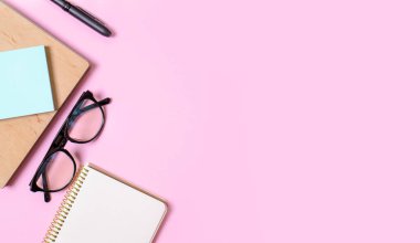 Not defterli pembe arka plan, ofis gözlükleri, kalem, mesaj için yer. Moda konsepti. Gelecek.