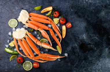 Taze yengeç pençeleri, kireç, baharatlar, baharatlar, buz, karides, arka planda sebzeler. Lezzetli deniz ürünleri, sağlıklı yiyecekler Diyet içeriği