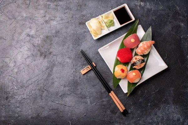 用米饭 熏鳗鱼 奶油芝士和飞鱼制成的寿司卷 用鳄梨 奶油芝士 生姜等调味后放在深色桌子上 — 图库照片