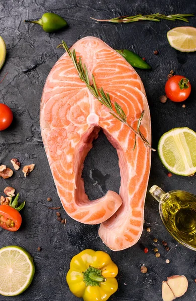 暗い背景にオリーブオイルと新鮮な赤マスの魚のステーキ 魚介類野菜オメガ 上からの眺め健康食品 — ストック写真