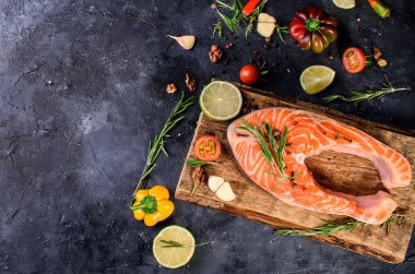Büyük bir parça taze balık somonu, baharatlar, domates, limon, biberiye, yağ, yağ. Vücut için yararlı yiyecekler. Omega, düzgün beslenme.